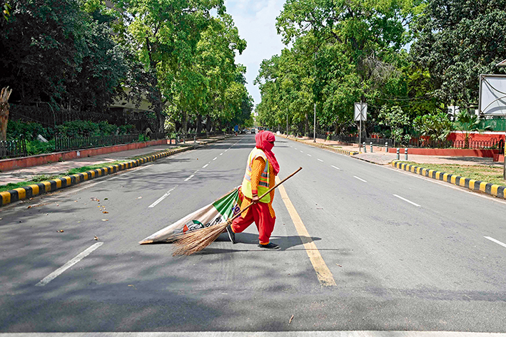 一名清洁工人穿过印度新德里一条马路 新华社/法新 一名清洁工人穿过印度新德里一条马路 新华社/法新